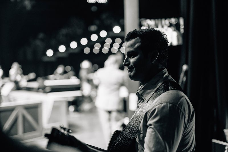 Black and white Easton smiling side stage, Opry lights