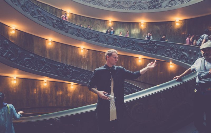 Friend gesturing on lamp lit spiral stair