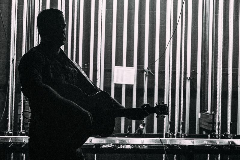 Close silhouette with guitar against rigging rails