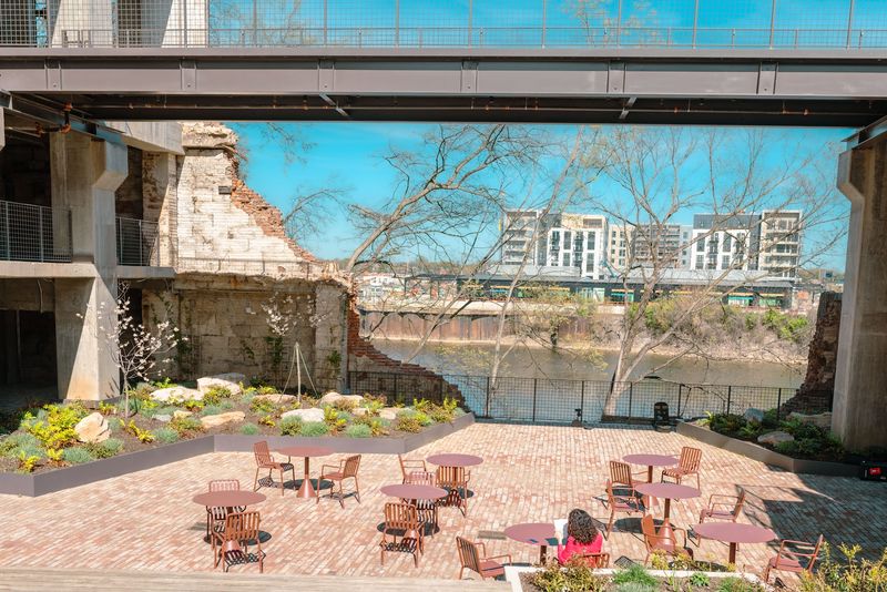 Framed river view under skybridge over plaza tables