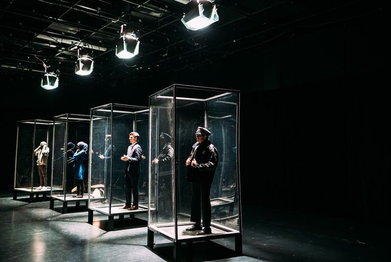 Receding glass boxes with cast, lamps overhead