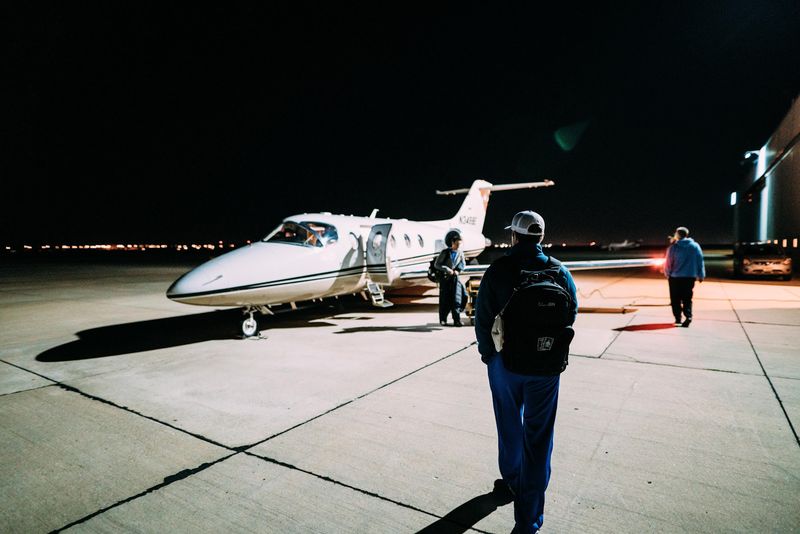 Crew member with backpack walking toward lit jet