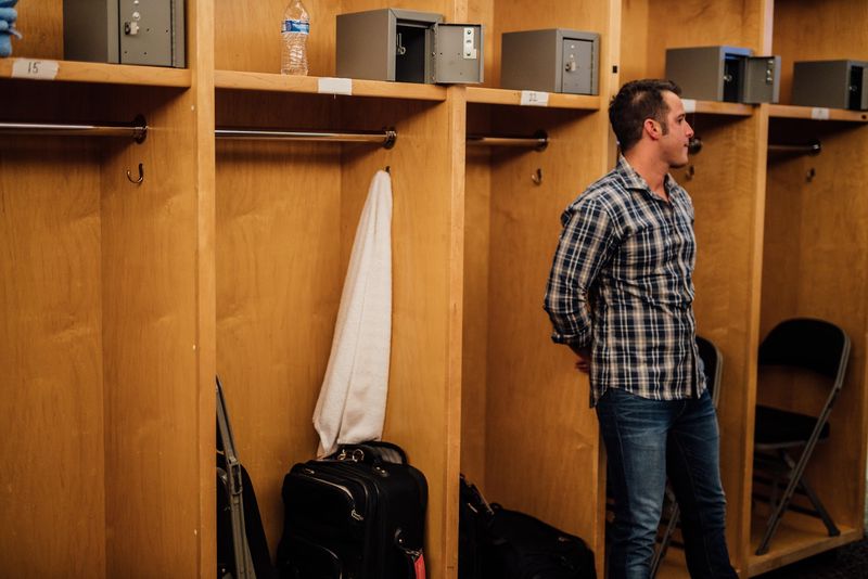 Corbin standing alone by wooden lockers
