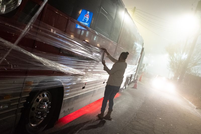 Silhouette wrapping bus in fog, red underglow