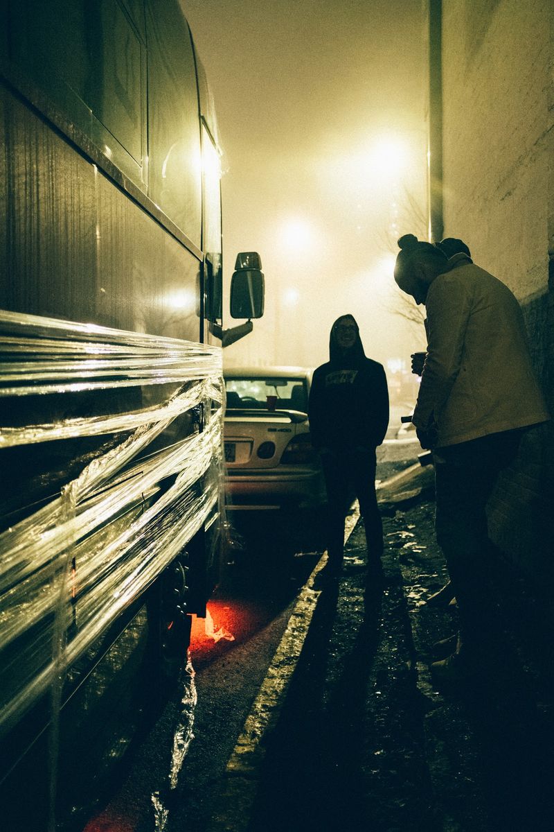 Vertical alley, wrapped bus, figures in fog