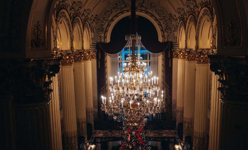Chandelier above lobby Christmas tree, symmetrical gilded columns