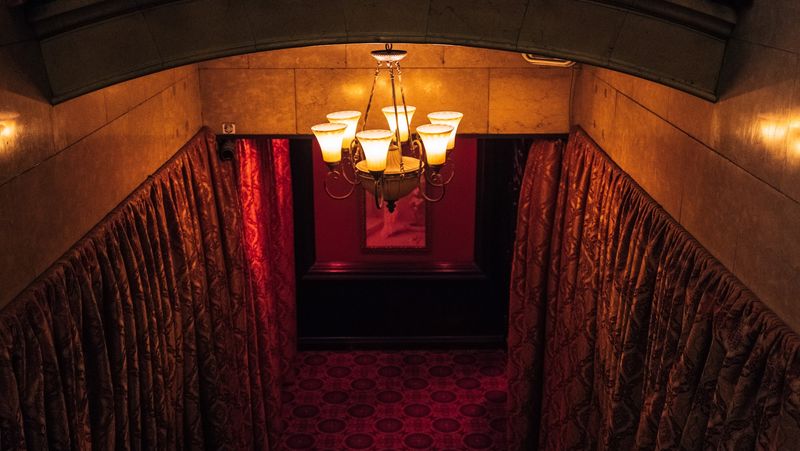 Red velvet stairwell with chandelier, symmetric