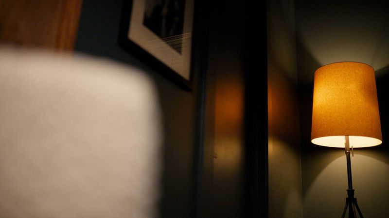 Amber floor lamp framed past soft foreground blur