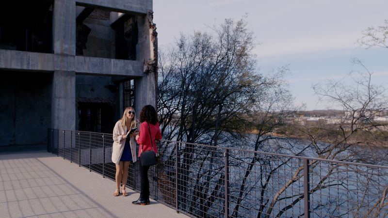 Two women talking at rail above river