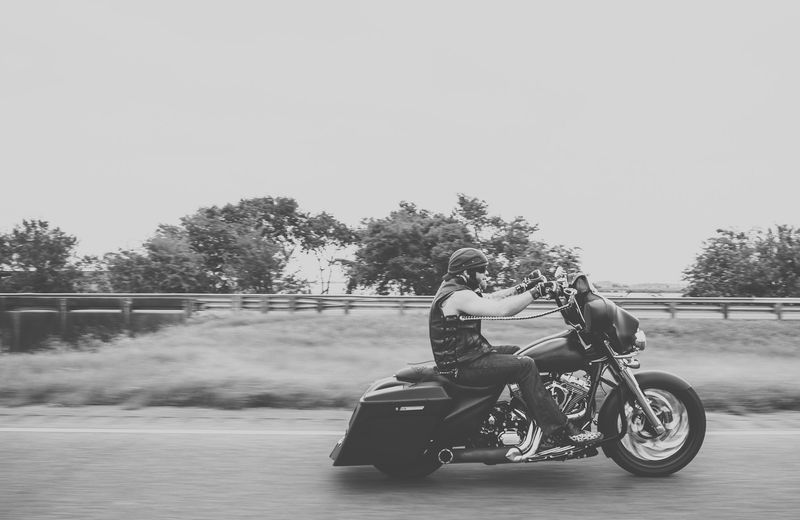 Black and white rider in motion, motion-blurred grass