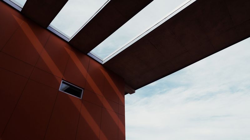 Red facade and louvered canopy angled against sky
