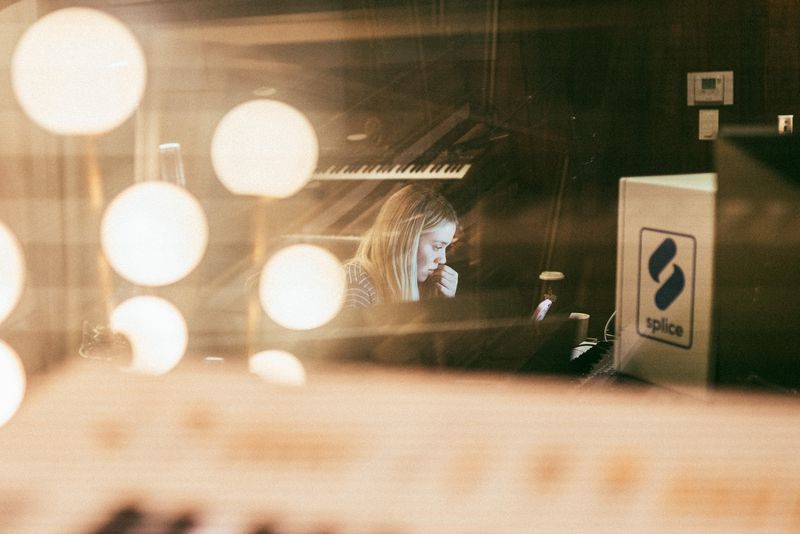 Bokeh globe lights frame songwriter behind glass