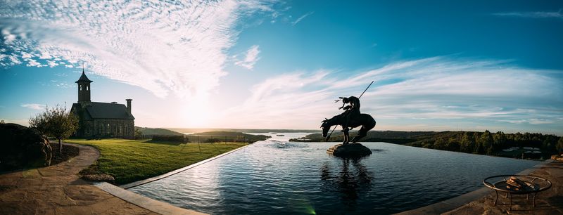 Panoramic chapel and horseback sculpture over infinity pool