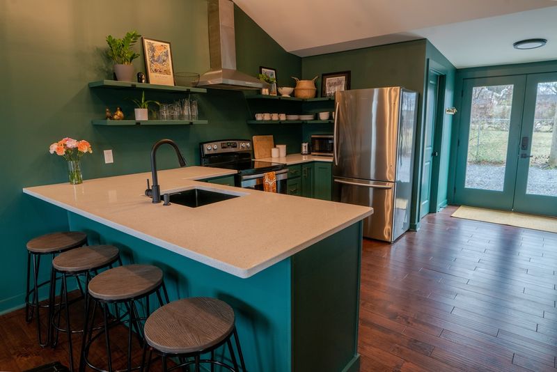 Peninsula with stools, fridge and french doors beyond