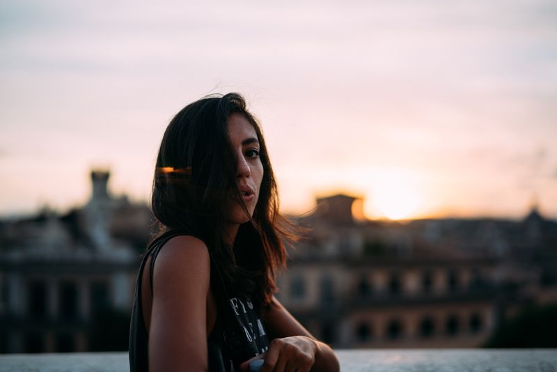 Woman looking back at camera against Rome sunset
