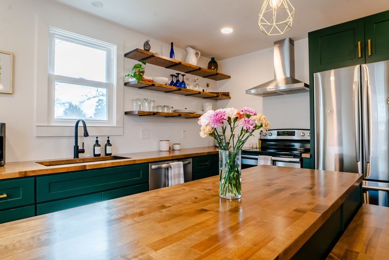 Kitchen island with carnations, open shelves, green cabinets