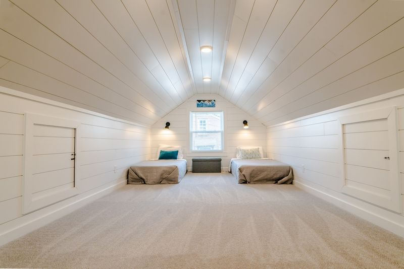 Symmetrical shiplap attic bunk room, twin beds, window