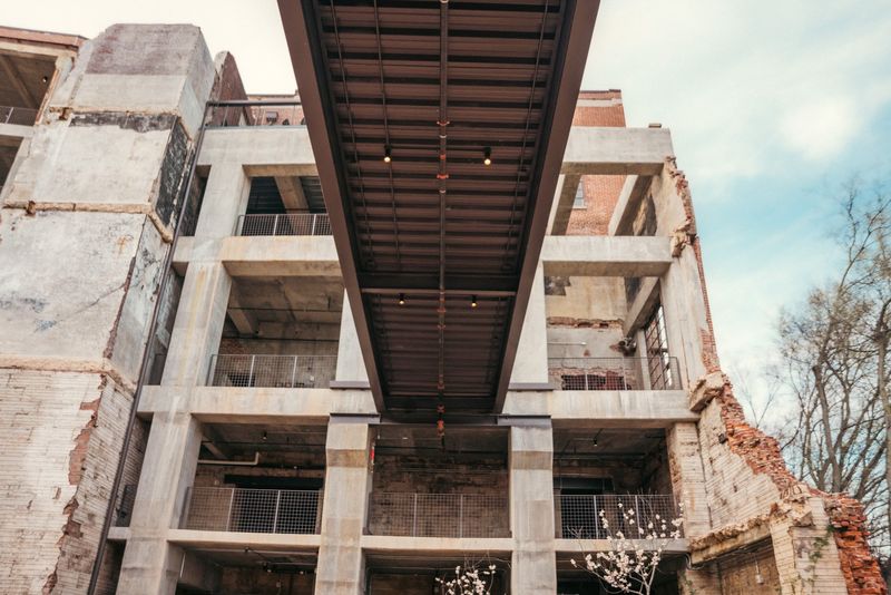 Looking up at skybridge splitting concrete mill ruin