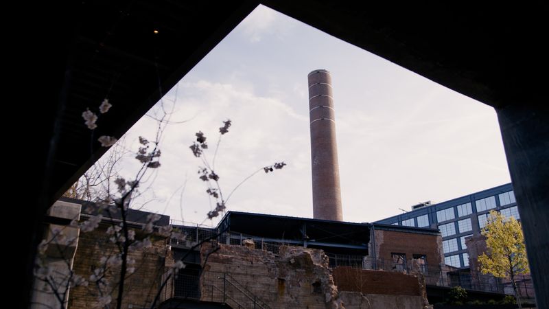 Dark ruin opening framing smokestack against sky