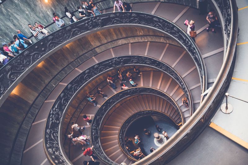 Spiral staircase from above, people circling the rail