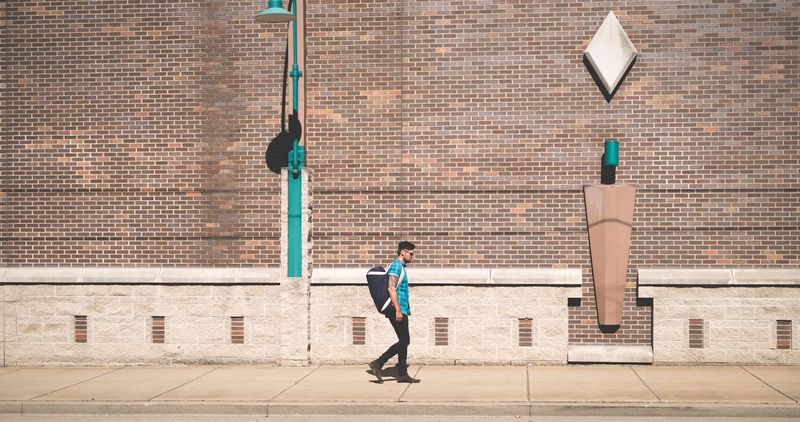 Small walker in teal echoes the teal lamppost on brick