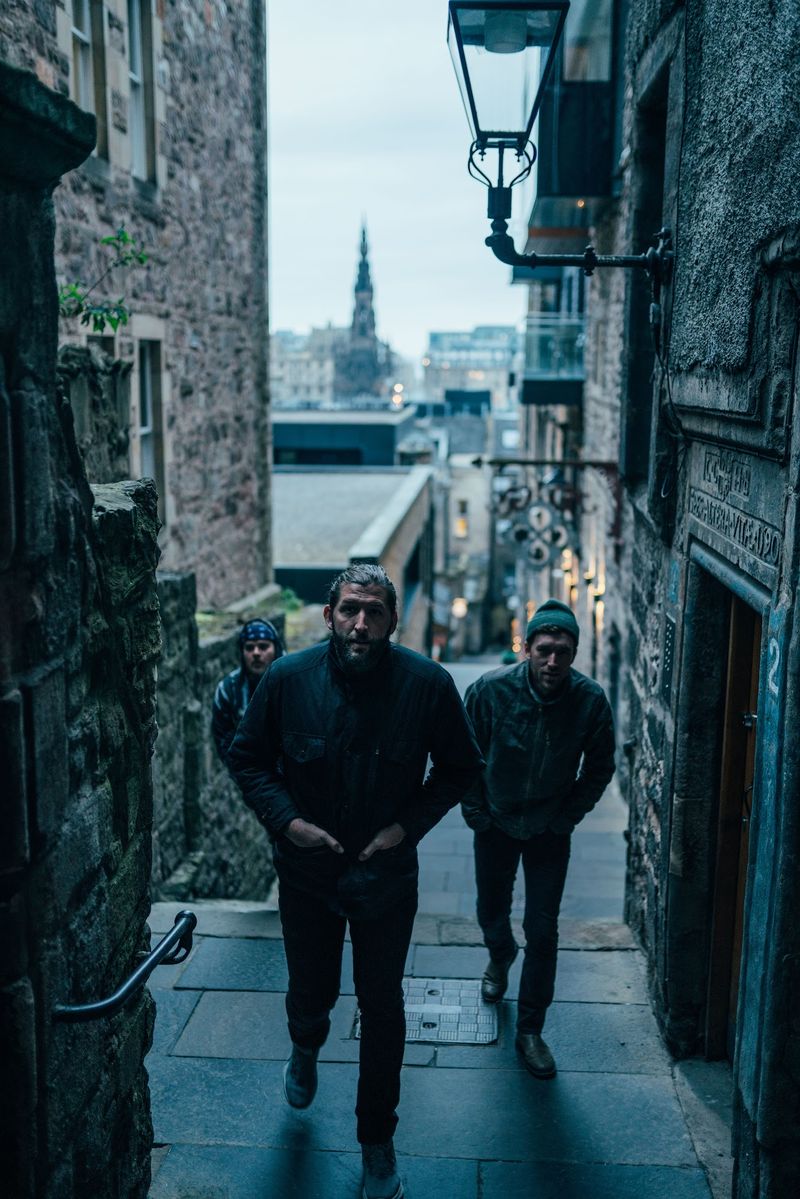 Two men climb a blue-hour stair under a lamp