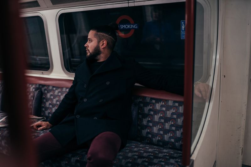 On a Tube seat gazing out, roundel sign and moquette behind