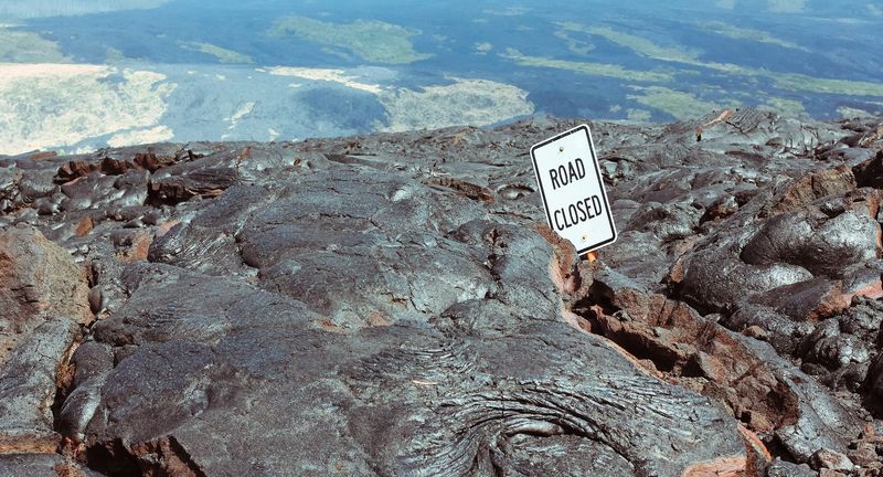 ROAD CLOSED sign swallowed by black lava flow